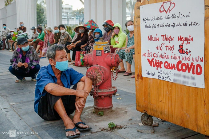 Người dân chờ nhận quà từ một nhóm từ thiện trên đường Lý Chính Thắng (TP HCM) hồi tháng 4. Ảnh: Nguyệt Nhi.