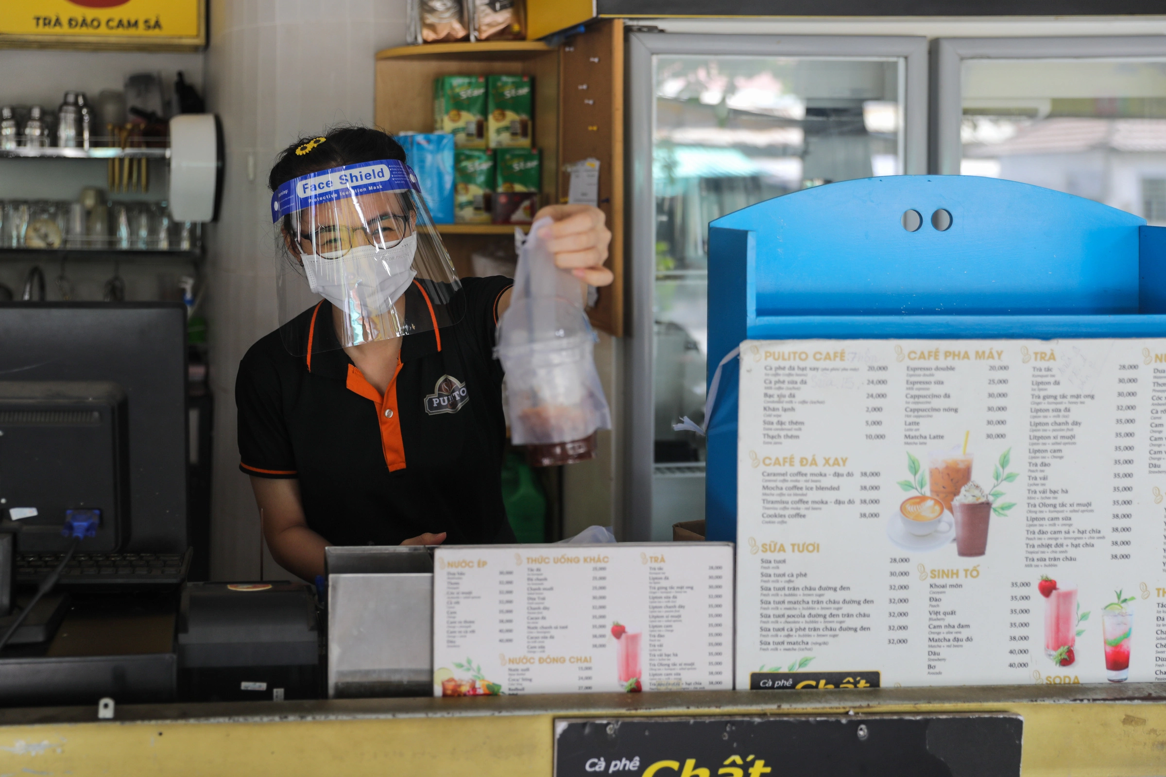 Nhân viên một tiệm cà phê ở quận 7 bán hàng cho khách mang về, ngày 16/9. Ảnh: Quỳnh Trần QUYN4539-7329-1633416117.jpg