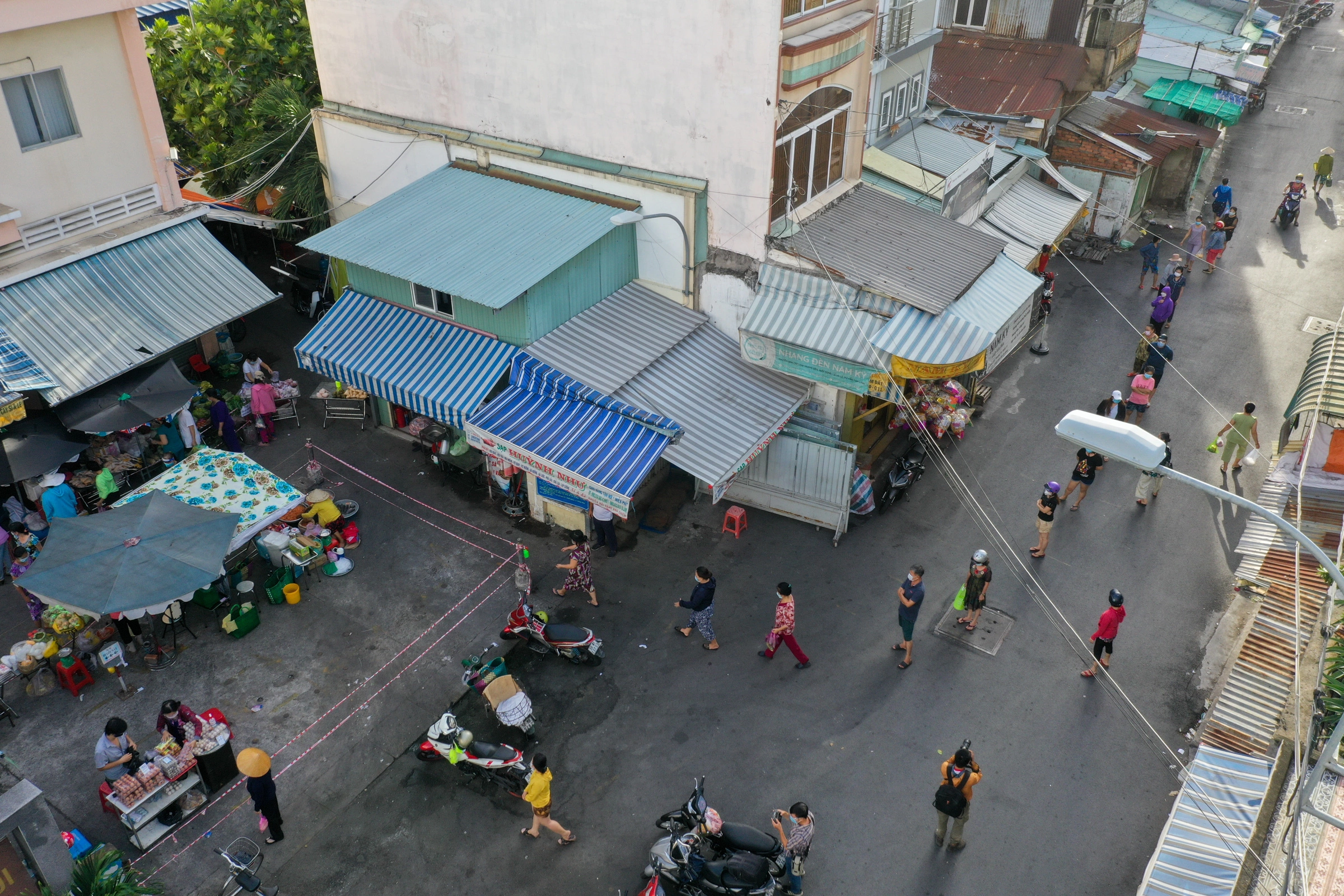 Người dân xếp hàng tại chợ Bình Thới (quận 11), khi nơi đây đóng cửa nhà lồng, chuyển sang bán ngoài sân, ngày 7/8. Ảnh: Quỳnh Trần DJI-0846-4559-1633527044.jpg