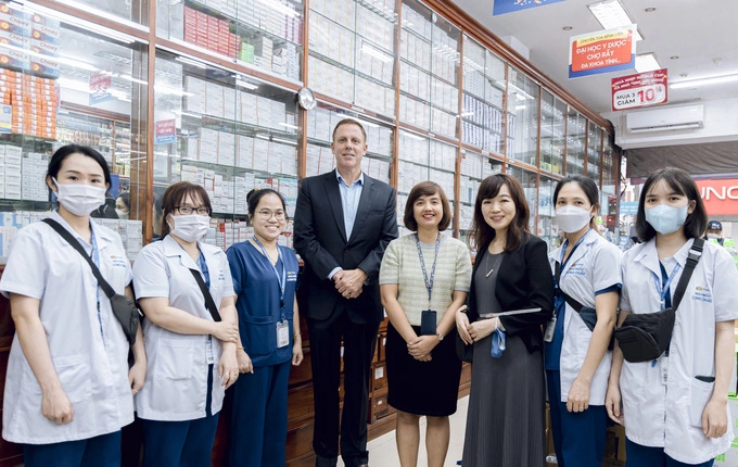 Ông Andre Musto – Phó chủ tịch Merck (đứng giữa) đến thăm và làm việc cùng bà Nguyễn Đỗ Quyên - Giám đốc điều hành FPT Long Châu (áo sọc giữa) tại nhà thuốc FPT Long Châu. Ảnh: FPT Long Châu