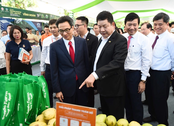 Phó thủ tướng Vũ Đức Đam cùng ông Trương Gia Bình - Chủ tịch HĐQT Tập đoàn FPT tham quan gian hàng FPT. Ảnh: Thanh Tùng