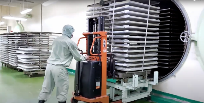 Nhân viên sử dụng máy móc đưa thành phẩm vào sấy. Ảnh: An An