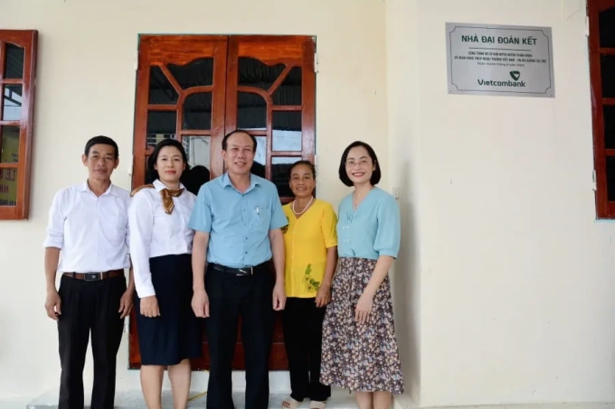 Các đại biểu chụp ảnh lưu niệm trước ngôi nhà mới xây. Ảnh: Vietcombank