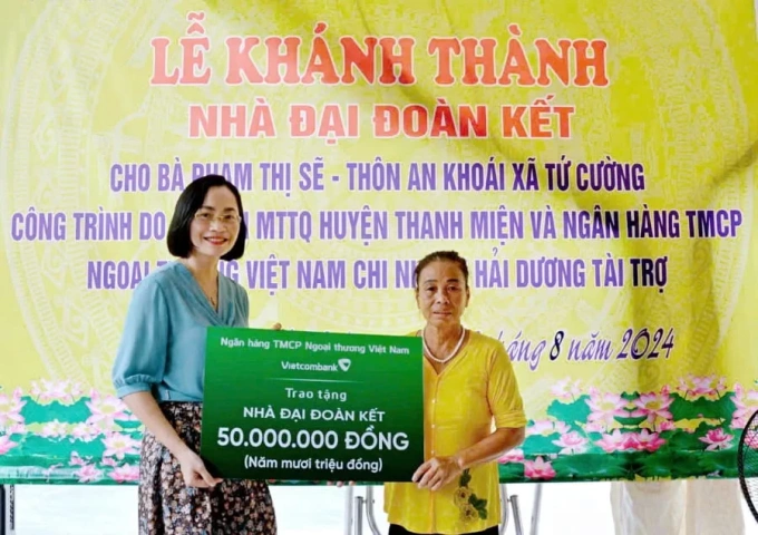 Bà Phạm Minh Đào - Phó giám đốc Vietcombank Hải Dương trao biển tài trợ xây dựng nhà cho bà Phạm Thị Sẽ. Ảnh: Vietcombank
