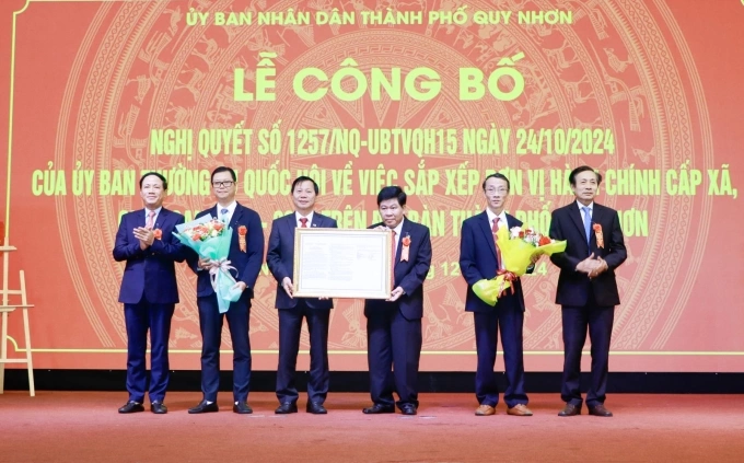 Chủ tịch UBND tỉnh Phạm Anh Tuấn - Trưởng ban Chỉ đạo sắp xếp đơn vị hành chính cấp xã của tỉnh giai đoạn 2023 - 2025 trao Nghị quyết cho lãnh đạo TP. Quy Nhơn