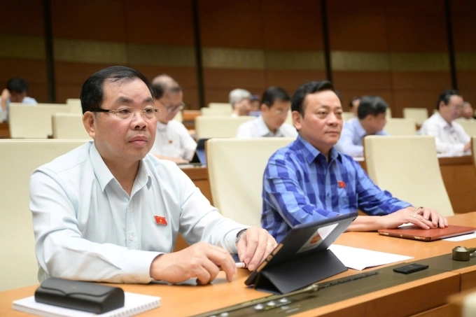 Các đại biểu nghe Bộ trưởng Tài chính Nguyễn Văn Thắng đọc báo cáo giải trình, trước khi bấm nút thông qua Luật Ngân sách (sửa đổi), sáng 25/6. Ảnh: Cổng TTĐT Quốc hội