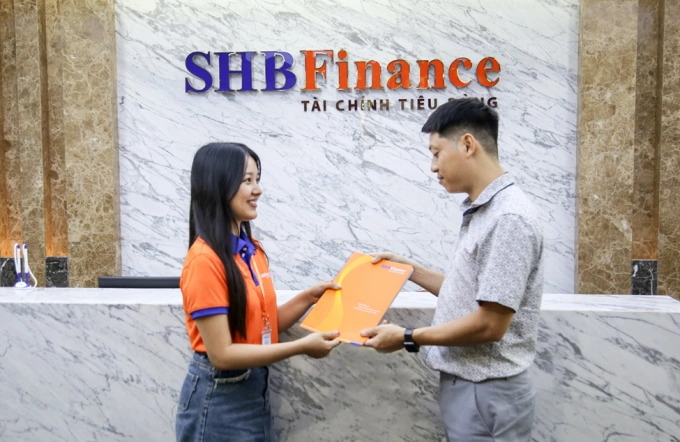 Nhân viên SHBFinance trao hợp đồng vay cho khách hàng. Ảnh: SHBFinance