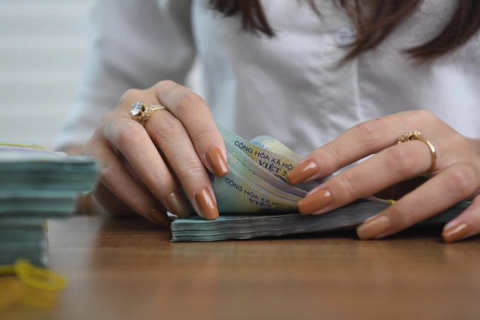 Đếm tiền tại một phòng giao dịch ngân hàng ở Hà Nội. Ảnh: Giang Huy