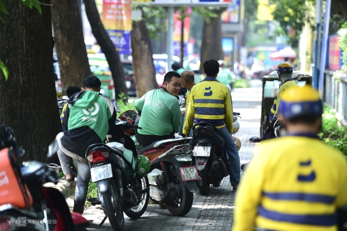 Tài xế xe công nghệ chờ khách trên đường ở trung tâm TP HCM, ngày 24/5. Ảnh: Thanh Tùng