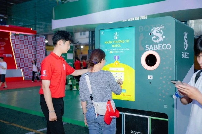 Người tham dự khám phá và tương tác với máy tái chế bao bì. Ảnh: Sabeco