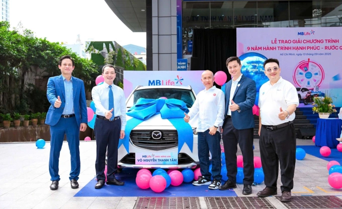 Ông Võ Nguyễn Thanh Tâm (thứ 3 từ phải sang) chụp ảnh cùng lãnh đạo MB Life bên cạnh giải thưởng ô tô Madza CX3. Ảnh: MB Life