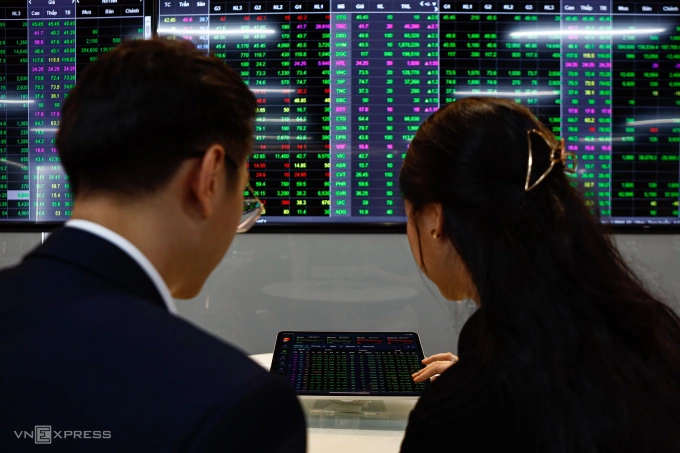 Nhà đầu tư đang quan sát bảng điện tử tại trụ sở một công ty chứng khoán ở TP HCM. Ảnh: An Khương