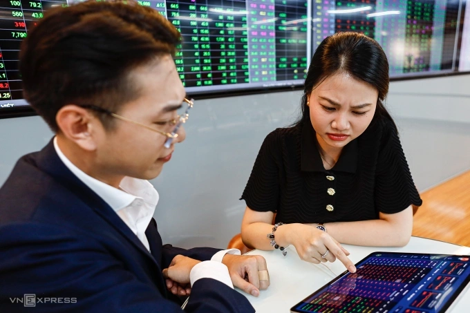 Nhà đầu tư đang quan sát bảng điện tại một công ty chứng khoán ở quận 1, TP HCM. Ảnh: An Khương