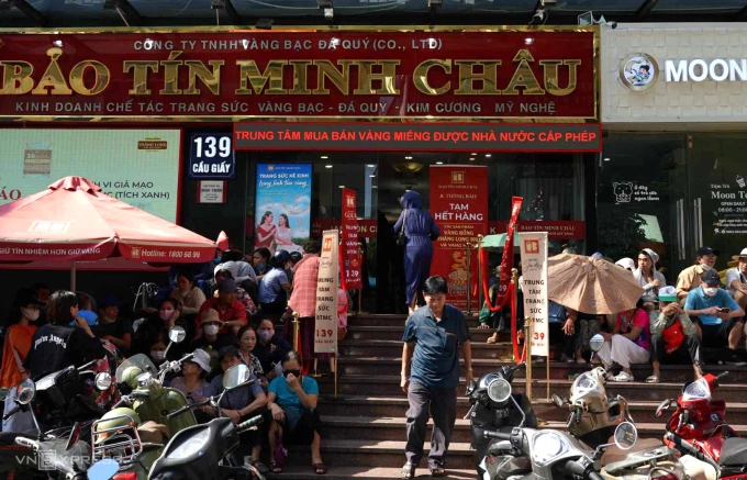 Người dân xếp hàng, ngồi chờ mua vàng trước cửa hàng Bảo Tín Minh Châu, 139 Cầu Giấy, sáng 17/10. Ảnh: Hoàng Giang