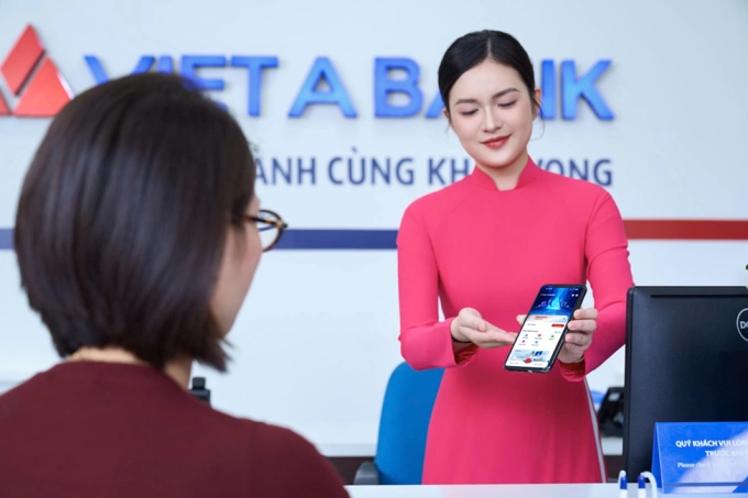 Giao dịch viên hướng dẫn khách hàng sử dụng nền tảng Ngân hàng số thế hệ mới. Ảnh: VietABank
