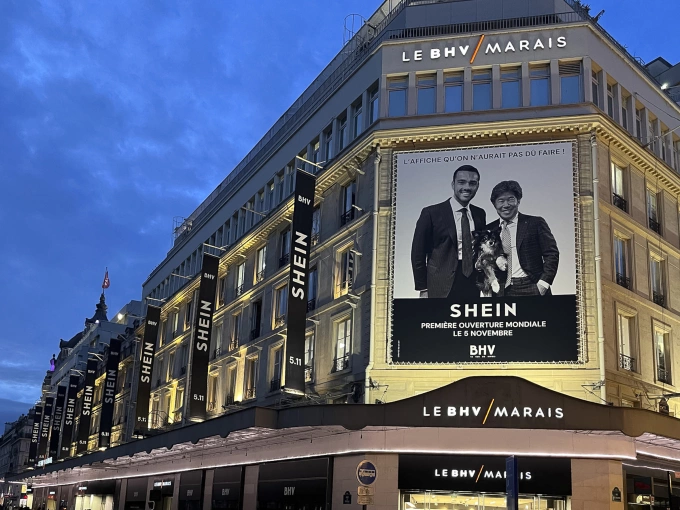 Quảng cáo Shein tại trung tâm thương mại BHV vớihình Chủ tịch SGM Frédéric Merlin (bên trái), Chủ tịch điều hành Shein Donald Tang và chú chó Satchi. Ảnh: Reuters