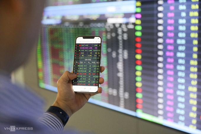 Tham khảo mô hình quốc tế Nhà đầu tư đang theo dõi bảng điện tử tại một công ty chứng khoán ở TP HCM. Ảnh: Quỳnh Trần