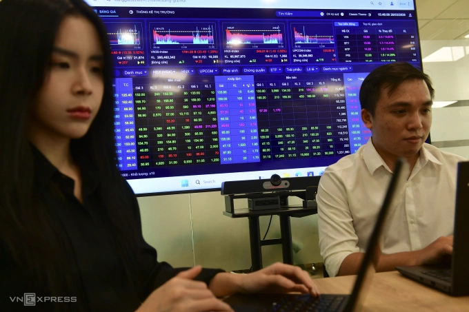 Nhà đầu tư theo dõi thị trường chứng khoán tại một công ty ở TP HCM. Ảnh: Thanh Tùng