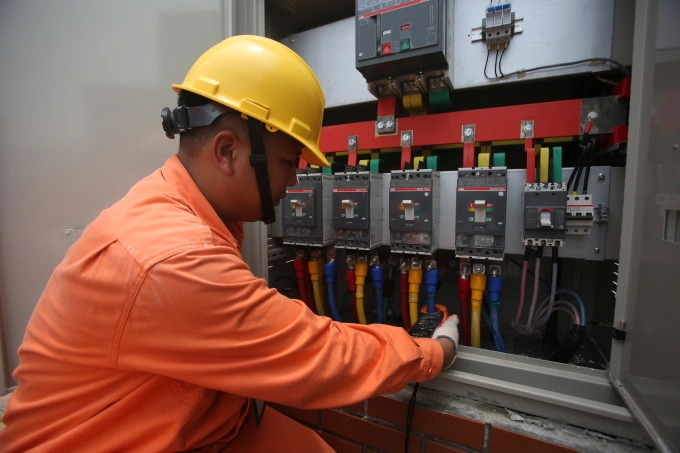 Nhân viên ngành điện đang kiểm tra thiết bị. Ảnh: Ngọc Thành