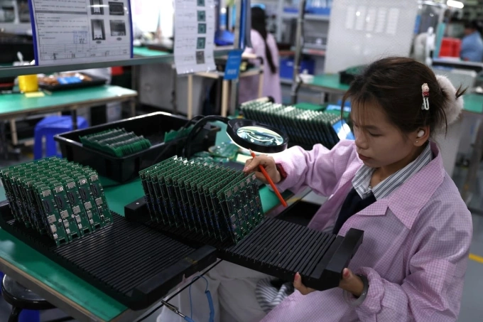 Nhân viên kiểm tra bảng mạch tại một nhà máy đối tác của Agilian Technology ở Đông Quản. Ảnh: Reuters