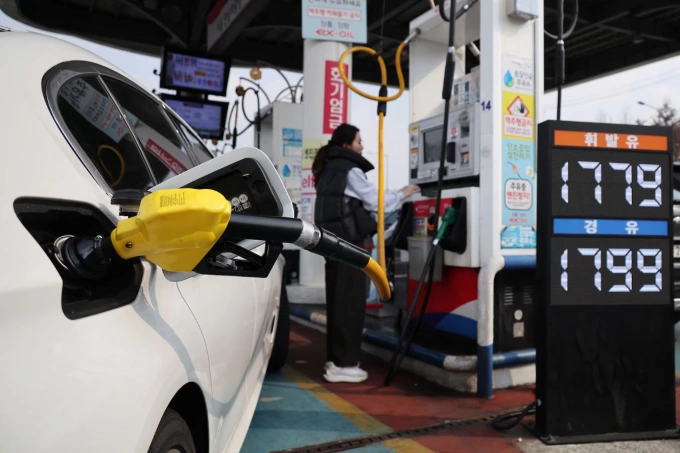 Một phụ nữ Hàn Quốc đổ xăng tại Seoul ngày 9/3. Ảnh: Reuters