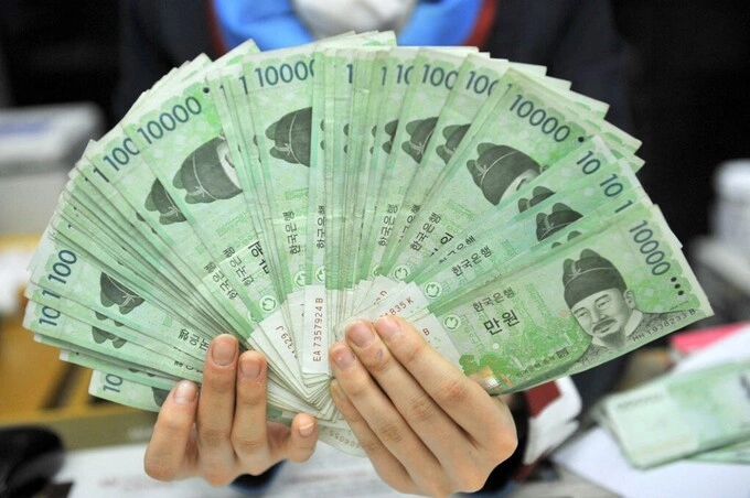 Nhân viên ngân hàng cầm tiền giấy won Hàn Quốc ở Seoul. Ảnh: AFP