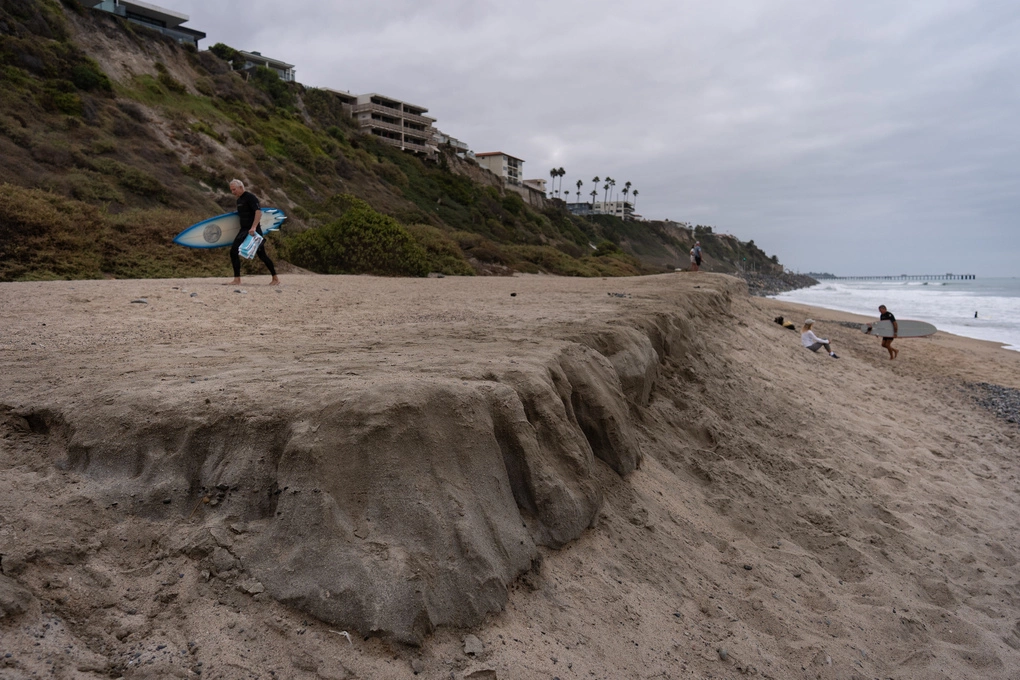 Những người lướt ván đi dọc theo bãi biển North Beach ở San Clemente, California, ngày 18/9. Ảnh: AP